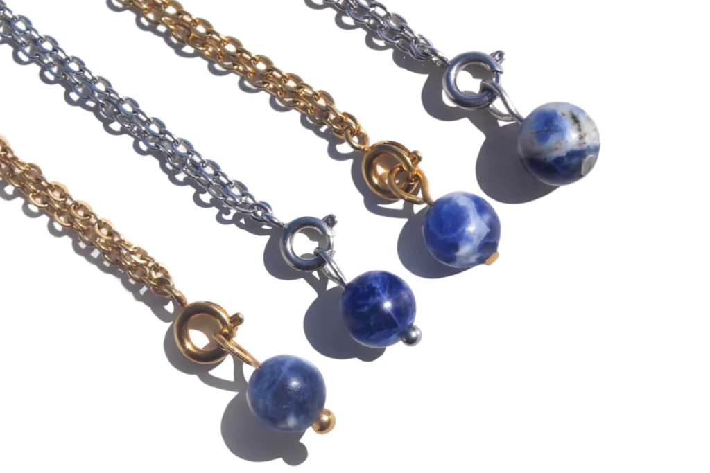 Pingentes de sodalite natural azuis com corrente em aço inoxidável dourado e prateado, cristal associado à clareza mental e comunicação.